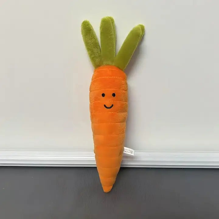 Long orange carrot plush with green leafy top and smiling face