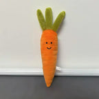 Long orange carrot plush with green leafy top and smiling face