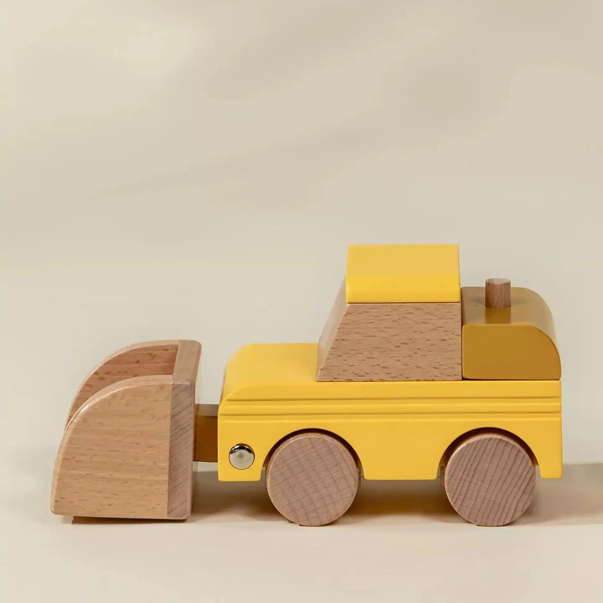 Coco Village wooden bulldozer toy in yellow and natural wood, side view