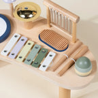 Close-up of wooden musical station with pastel xylophone, cymbal, and chime bars