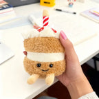 Birthday cake plush charm with candle and frosting layers held in a hand