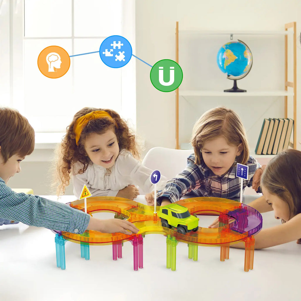 Children building a colorful PicassoTiles magnetic race track loop on a table