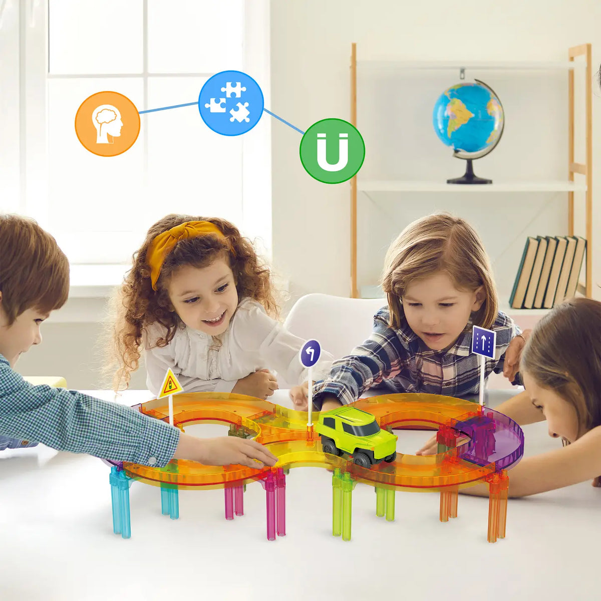 Children building a colorful PicassoTiles magnetic race track loop on a table