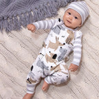 Baby lying on a knit blanket wearing a puppy print romper and striped hat