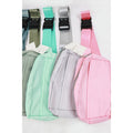 Four crossbody belt bags in sage, mint, light gray, and pink with black clip buckles