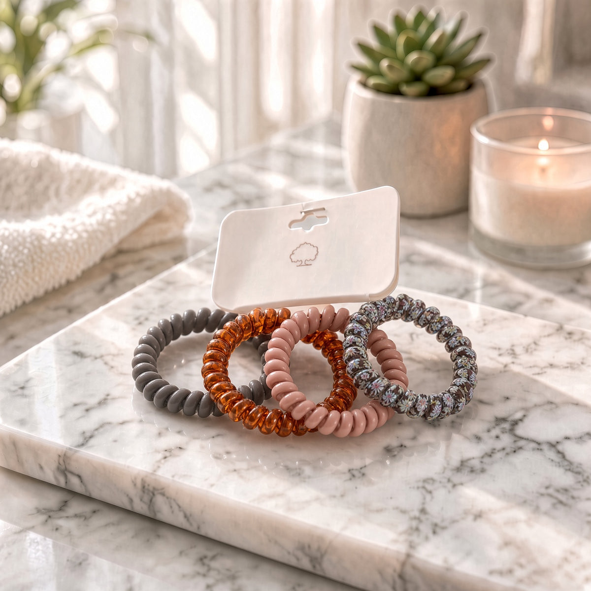 Gray, copper, and pink spiral coil hair ties on a card