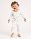 Toddler wearing a white two-piece long-sleeve pajama set with a small print