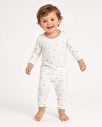 Toddler wearing a white two-piece long-sleeve pajama set with a small print