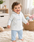 Baby wearing a light hooded button jacket with blue pants