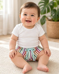 Baby wearing rainbow stripe drawstring shorts with a mint bow and white onesie