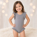 Girl wearing a gray one-piece tank swimsuit with shoulder ruffles