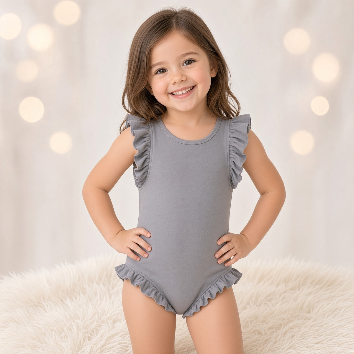 Girl wearing a gray one-piece tank swimsuit with shoulder ruffles