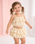 Toddler wearing a cream ruffle crop top and ruffle skirted shorts set