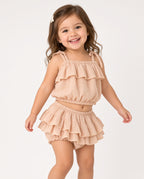 Toddler in a peach ruffle two-piece set with tiered crop top and skirted shorts