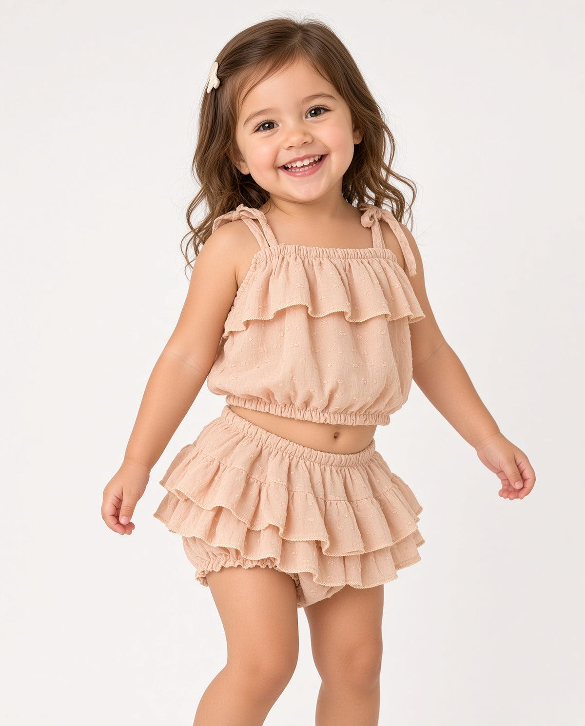 Toddler in a peach ruffle two-piece set with tiered crop top and skirted shorts