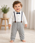 Toddler wearing a baby tuxedo snap romper with navy bow tie, faux suspenders, and gray legs