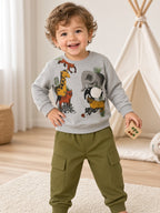 Toddler wearing a gray forest animal print sweatshirt and olive green cargo pants