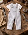 Toddler blue pinstripe overalls with front pocket and buttons over a white tee, flat lay