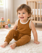 Baby wearing a camel sleeveless tank romper with white trim