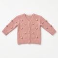 Pink knit baby cardigan with bobble pom-pom texture and buttons, flat view
