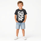 Boy wearing a black SURF graphic tee with denim shorts