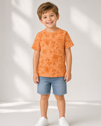 Boy wearing an orange nautical print tee with denim shorts