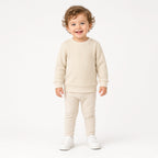 Toddler wearing a cream waffle knit long-sleeve crewneck with cream pants