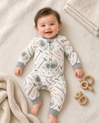 Baby wearing a footless zip sleeper with tool print and gray cuffs
