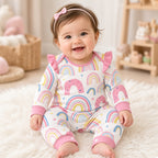 Baby wearing a rainbow print ruffle-shoulder snap romper with pink cuffs