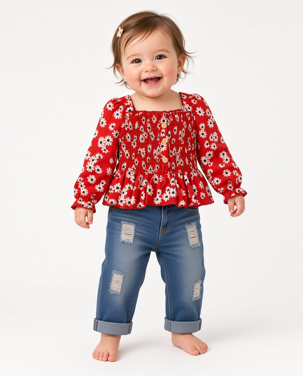 Baby wearing a red daisy print smocked long-sleeve top and distressed jeans