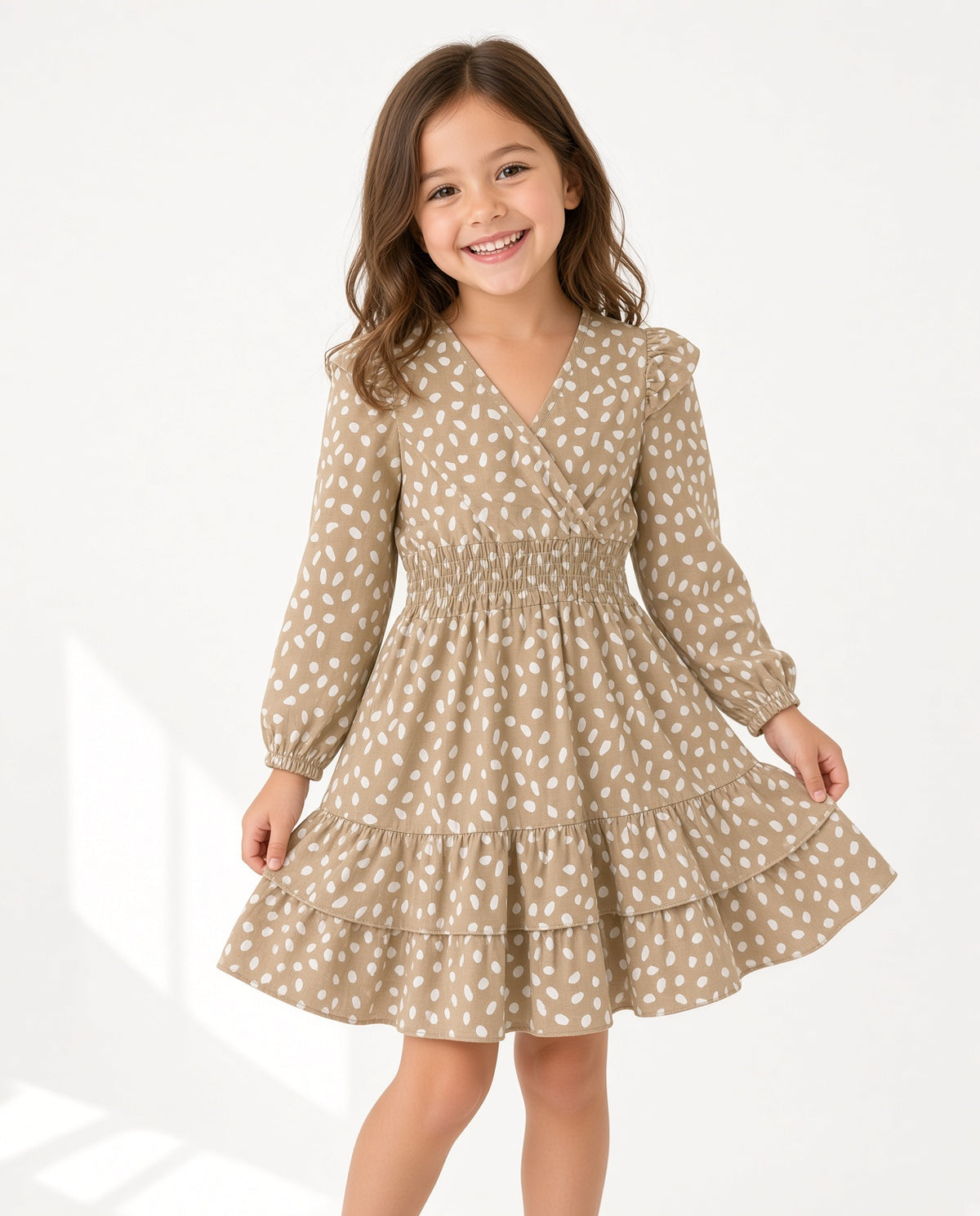Girl wearing a tan spot print smocked wrap dress with ruffle tiers
