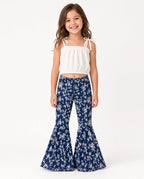 Girl wearing a white tie-strap crop top and navy floral bell-bottom pants