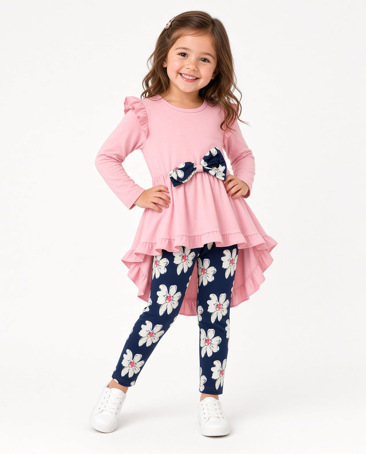 Girl wearing a pink high-low tunic with bow and navy daisy print leggings