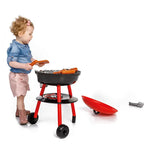 Toddler playing with the Paradiso Toys red and black kids BBQ grill and play food
