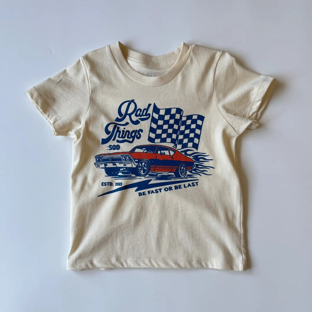 Cream kids graphic tee with Rad Things race car and checkered flag print, angled view