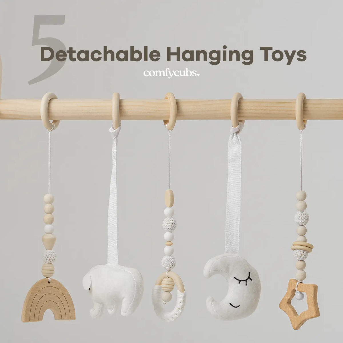 Close-up of five detachable hanging toys on the wooden play gym bar, including rainbow, moon, and star