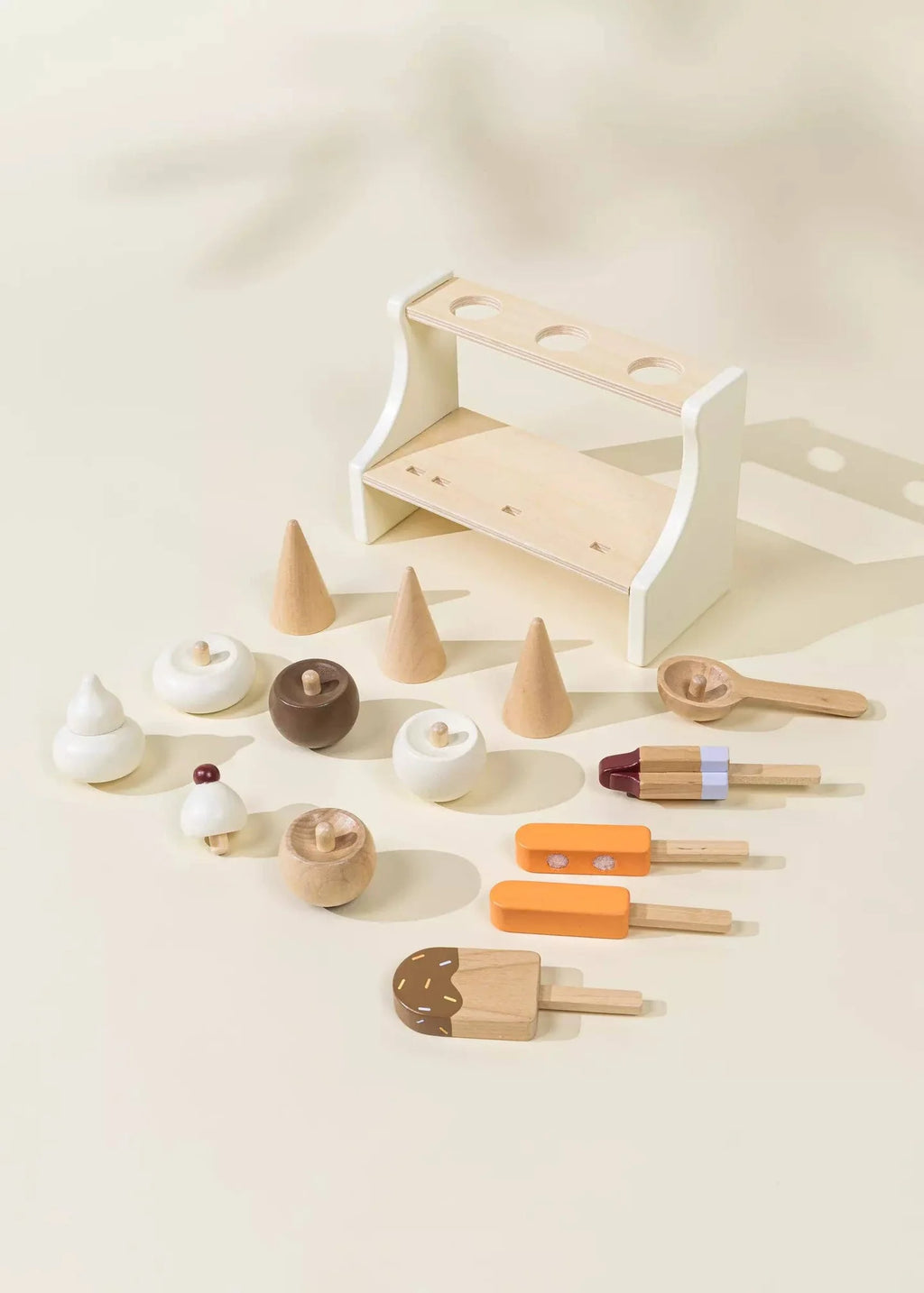 Wooden ice cream playset pieces laid out: stand, cones, scoops, and popsicles