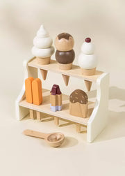 White wooden ice cream stand with toy cones, popsicles, and scoop, front view