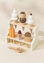 White wooden ice cream stand with toy cones, popsicles, and scoop, front view