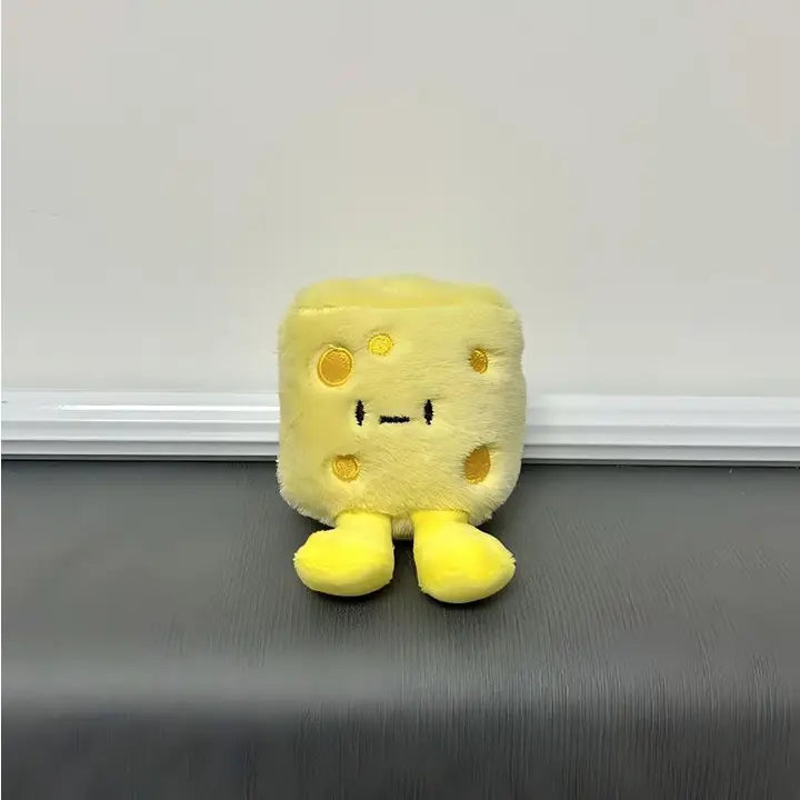 Yellow chunky cheese plush charm with smiling face and little feet