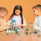 Three kids playing with a PicassoTiles magnetic castle and figures on a table