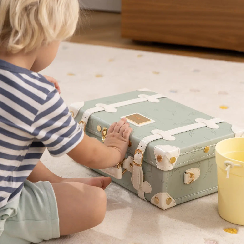 Child opening the latched sage green kids play suitcase