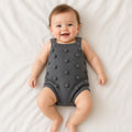 Baby wearing a gray knitted romper with bobble texture
