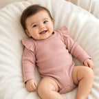 Baby in a dusty rose ribbed ruffle-shoulder long-sleeve bodysuit