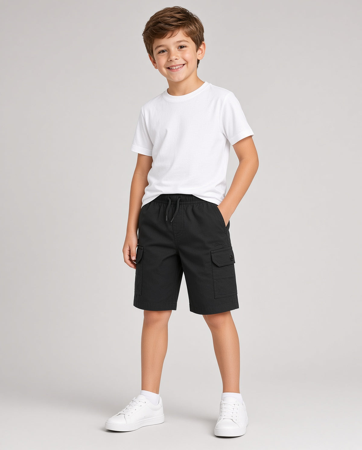 Boy wearing black Tommy Bahama twill cargo shorts with a white tee