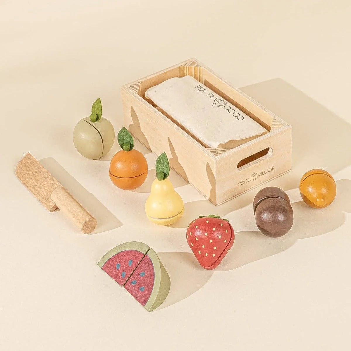 Wooden play fruits including watermelon, strawberry, pear, and orange with crate and knife